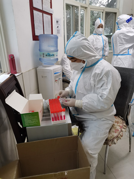 省计量院下沉干部韩冰在高新区紫薇田园都市社区协助打包核酸检测样品.jpg